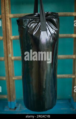 Punching bag in gym. Black punching bag for punch training. Sports equipment. Boxing Hall Details. Stock Photo