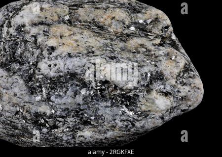 Closeup view of piece of granite rock with crysyals isolated on a black background Stock Photo