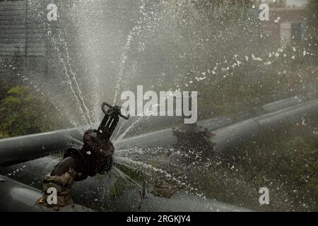 Valve on tube. Torn pipe valve. Boiling water pours from pipeline. Sewer breakout. Stock Photo