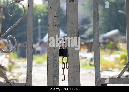 A lock on a chain hangs on an iron gate, closed, entry denied Stock Photo