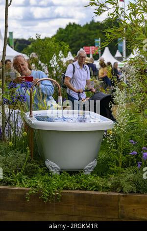 Person photographs water-feature bath (horticultural raised bed competition winner) - RHS Tatton Park Flower Show 2023 showground, Cheshire England UK Stock Photo