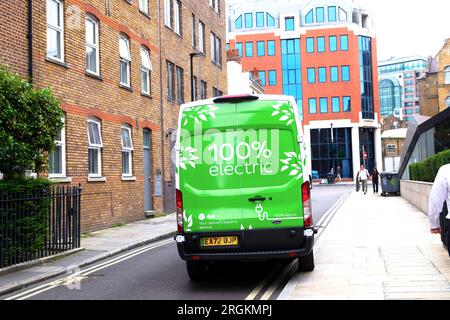 Rear view of 100% electric sign on the back of a green delivery van stopped outside flats building in the City of London England UK 2023 KATHY DEWITT Stock Photo