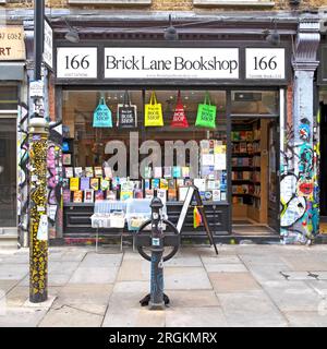 Exterior view of Brick Lane Bookshop shop bookstore shopfront exterior books book bags outside window on 166 Brick Lane East London UK   KATHY DEWITT Stock Photo