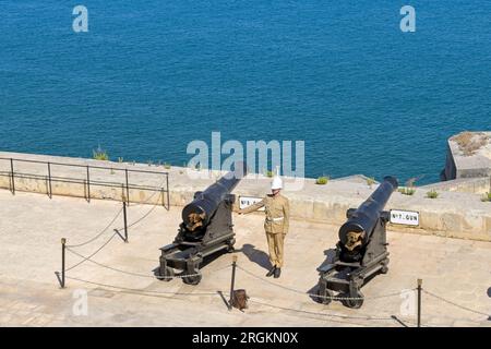 Valletta, Malta - 8 June 2023: Solider in traditional uniform preparing to fire the evening gun salute over the harbour Stock Photo