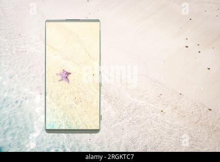 Clarity and vivid colors of the smartphone screen, Smartphone with the image of the starfish on the sand beach, right copy space for text, phone scree Stock Photo
