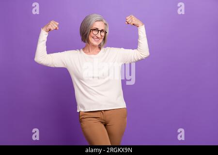 Photo of charming business lady show double biceps muscles arms fists up big experience market leader isolated over purple color background Stock Photo