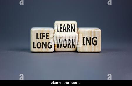 Lifelong learning working symbol. Concept word Lifelong learning working on block on a beautiful grey table grey background. Business educational life Stock Photo