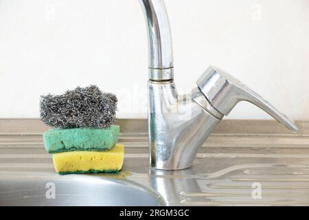 Dirty kitchen sponges and a metal ruff lie on the kitchen sink in the kitchen at home Stock Photo