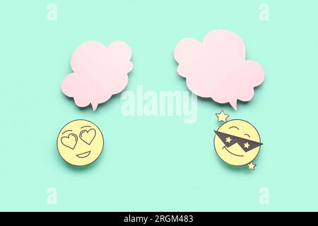 Paper faces with blank speech bubbles on turquoise background Stock Photo