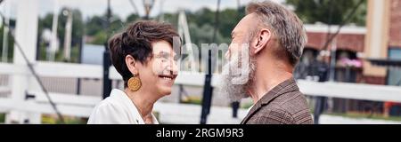happy senior woman hugging man, looking at each other outdoors, romance, elderly couple, banner Stock Photo