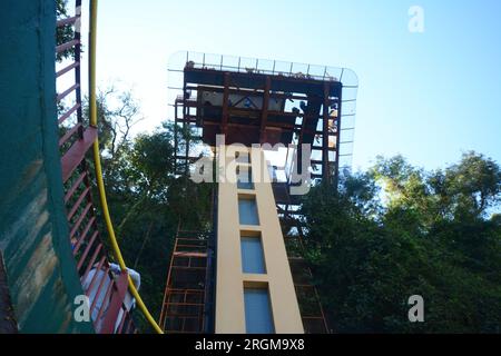 Bottom view of the panoramic elevator platform of the Iguazu Falls with several tourists on a sunny day and blue sky. Stock Photo