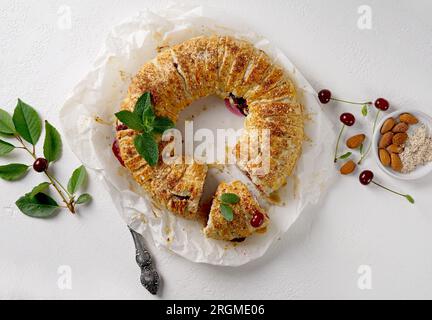 freshly baked cherry strudel with mint and almond and fresh cherries at the background Stock Photo