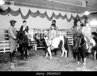 Toy department of Woodward & Lothrop, children on ponies ca. 1924 Stock Photo