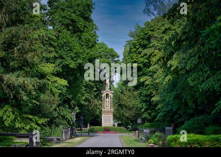 the main path of the melaten cemetery in cologne with the central eagle column in summer Stock Photo