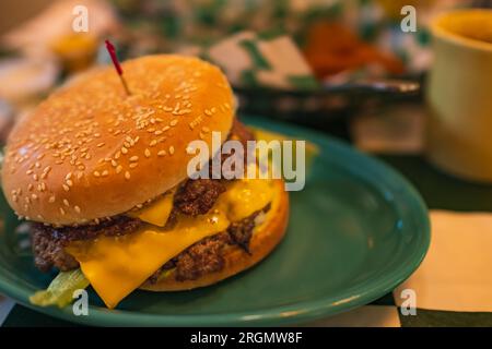 Double meet Burger with melting cheddar cheese. Cheeseburger burger with double cutlet. Big classic beef cheese burger on a plate. Fast food Burger, C Stock Photo