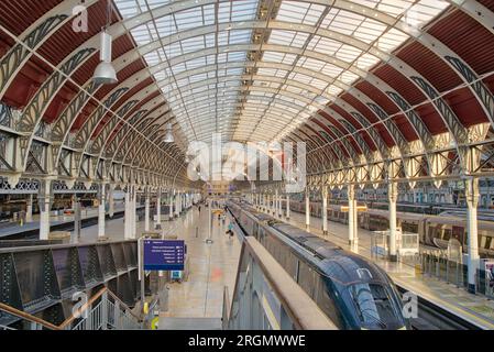 evening sun beam through arch roof top glasses onto Paddington station platform, GWR train is waiting for evening commuter passengers London UK Stock Photo