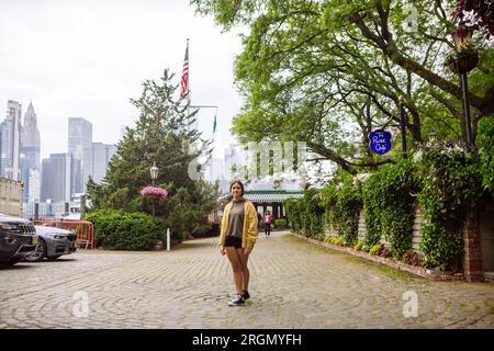 Young girl posing by the River Cafe in Dumbo, Brooklyn, USA Stock Photo