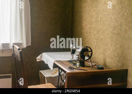 Old machanical sewing machine on table in Amuri museum of historic housing in Tampere Finland Stock Photo