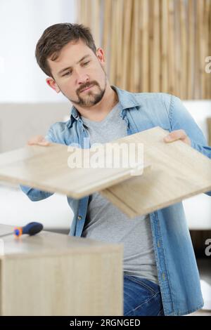 a man is assembling furniture Stock Photo
