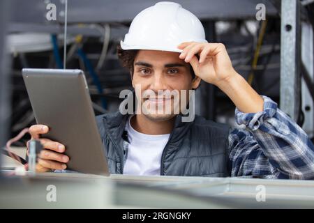 electrician with tablet computer in the ceiling Stock Photo