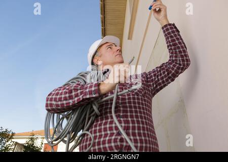 happy worker moving heavy pipes outdoors Stock Photo