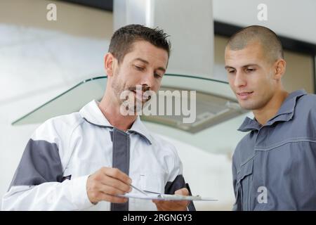 young male electrician repairing kitchen extractor filter Stock Photo