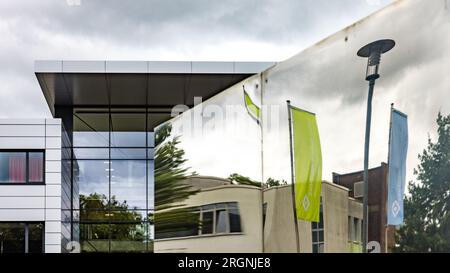 Cottbus, Germany. 01st Aug, 2023. Flags with the inscription 'Carl-Thiem-Klinikum Cottbus' are reflected in an installation in front of the main entrance to the clinic. To ensure a skilled workforce in nursing, 15 nursing specialists from Brazil have been trained since September 2022. The first of them have successfully completed their training as nursing specialists these days. (to dpa 'A specialist book for cardiology and two pugs on a diet') Credit: Frank Hammerschmidt/dpa/Alamy Live News Stock Photo