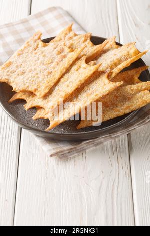 Oreillettes from Provence Mardi Gras Fritters closeup on the plate on the wooden table. Vertical Stock Photo