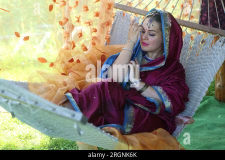 Woman in sari lies in a hammock Stock Photo