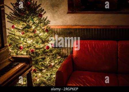 Cozy living room corner with christmas tree and piano. Stock Photo
