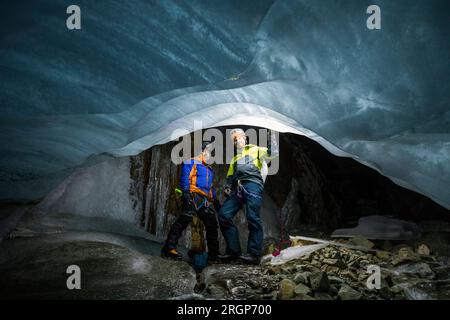 Portrait of two explorers wearing climbing gear in ice cave Stock Photo