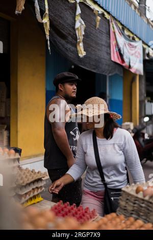 A young Indonesian man and a Balinese woman sell chicken eggs. Stock Photo