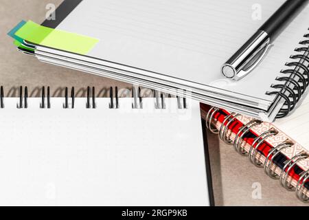 Several spiral notebooks and one pen lie on the office table. Stock Photo