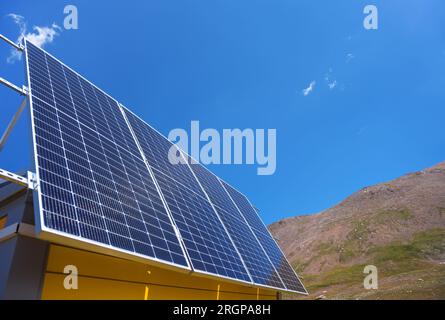 Solar panels are installed on the facade of the house. Mountain landscape. Sunny day Stock Photo