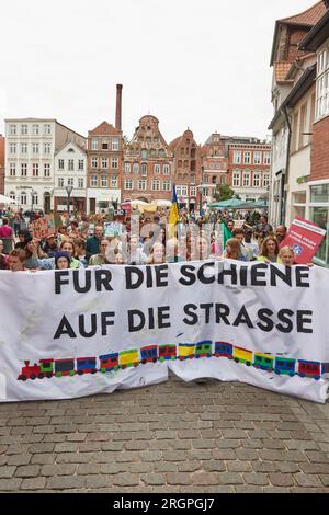 11 August 2023, Lower Saxony, Lüneburg: Participants of a protest march of the climate movement Fridays for Future carry a banner with the inscription ""For rail on the road"". The demonstration through Lüneburg is intended, among other things, to draw attention to the need for the new Hamburg-Hanover rail line. Photo: Georg Wendt/dpa Stock Photo