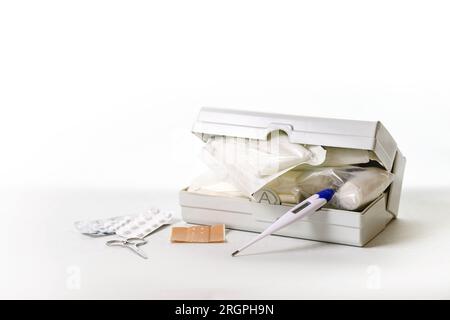 First aid kit for car and vacation or home medicine chest with bandages, plasters, fever thermometer, tablets and scissors, health and medical concept Stock Photo