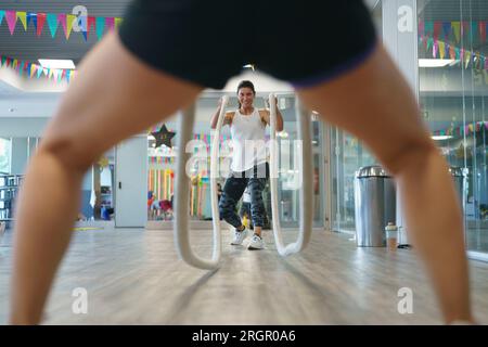 Young woman doing battle rope exercises Stock Photo