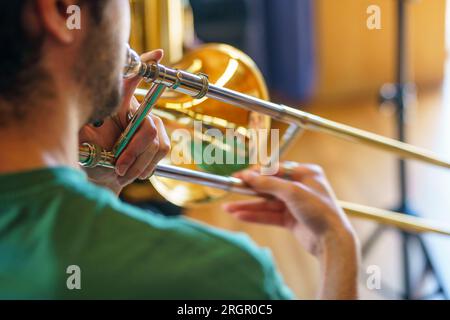 Close up of a man playing the trombone viewed from behind Stock Photo