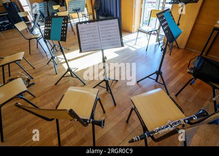 Empty philharmonic orchestra practice room with musical instruments and music stands Stock Photo
