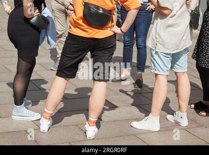 11 August 2023, Lower Saxony, Lüneburg: People are standing in a square in breezy clothes on this sunny and warm summer day. Photo: Georg Wendt/dpa Stock Photo