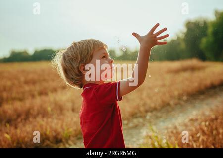 Little boy catches water droplets in the air Stock Photo