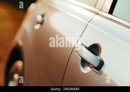 Close-up of the silver car door at sunset light Stock Photo