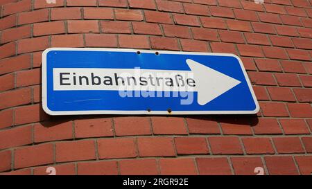 Traffic sign with German inscription Einbahnstraße on the facade of a house in Wismar in Germany. Translation: one-way street Stock Photo