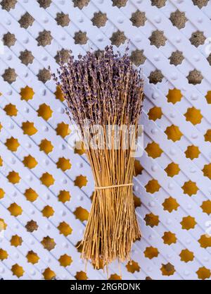 Bunch of lavender flowers. Dry lavender bouquet isolated on wooden pattern background. Stock Photo