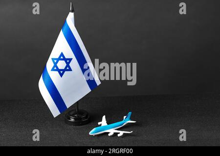 Small flag of Israel and toy plane on black background Stock Photo