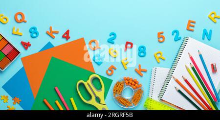 Back to school background. Plasticine, scissors, colored paper for crafts, pencils, notebook, ruler, plastic numbers and letters. Colorful stationery Stock Photo