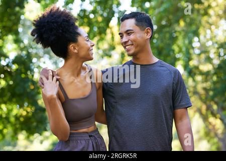 Beautiful young multi-ethnic couple exercise together in park, pose and smile Stock Photo