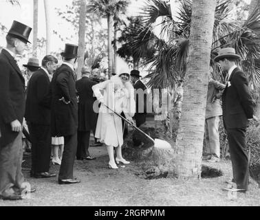 Mountain Lake, Florida:  February 3, 1929. Mrs. Calvin Coolidge wields a shovel and helps plant a palm tree at the dedication of the Mountain Sanctuary and Singing Towers. The are a gift from Edward Bok to the American people. Stock Photo