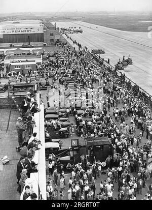 New York, New York:  July 14, 1938 Part of the huge crowd on hand at Floyd Bennett Airport in Brooklyn when Howard Hughes landed his Lockheed 14N Super Electra airplane after leaving there and flying around the world in a new record of 3 days, 19 hours and 14 minutes, breaking Wiley Posts's record. Stock Photo