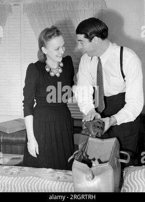 San Francosco, California:  c. 1940. The newly weds Dorothy Arnold and Joe DiMaggio bid adieu as Joe packs his glove for the start of baseball season with the New York Yankees. Stock Photo